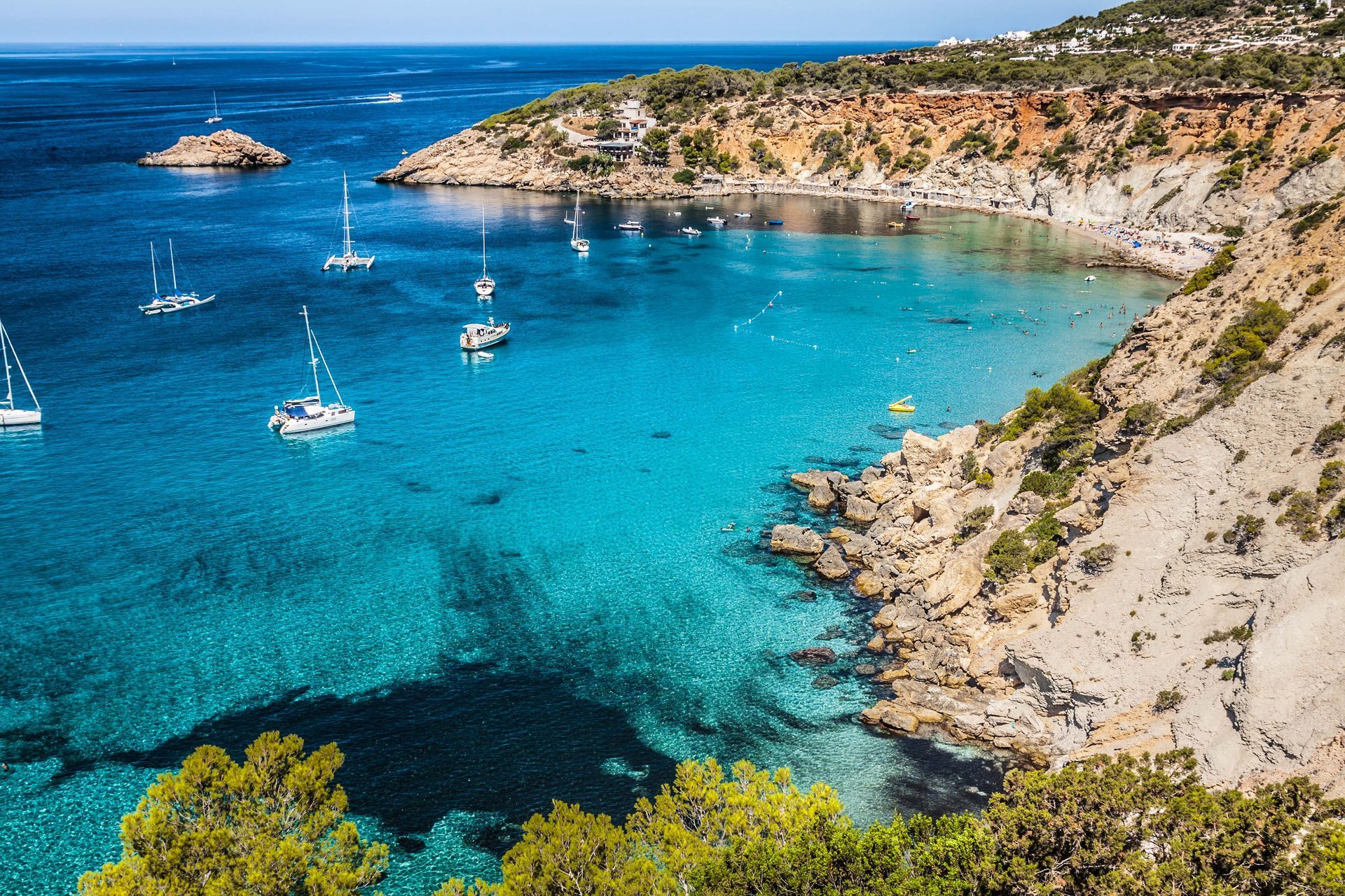 Catamarans and boats at Cala d’Hort, a beach in Ibiza, Spain.