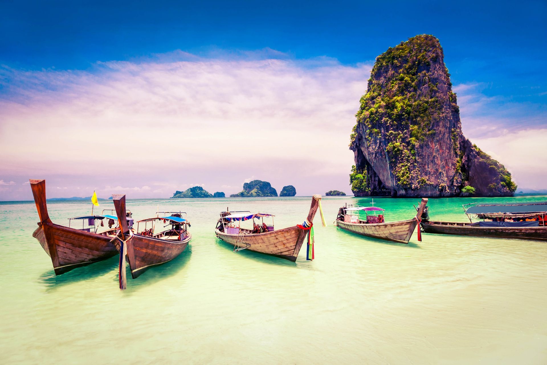 Boats stranded on the shoreline of Phra Nang Beach, a public beach in Thailand.