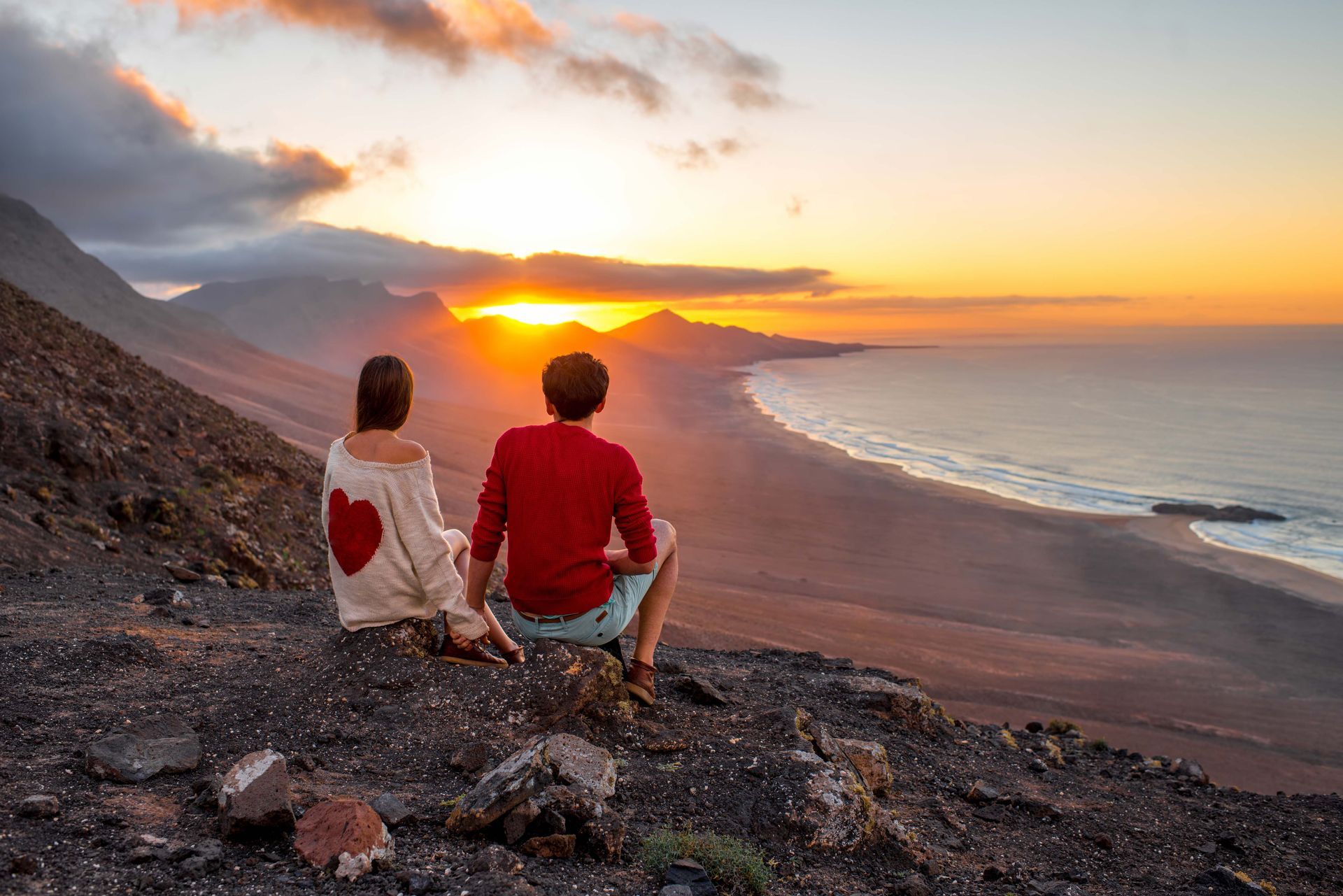 A couple enjoying a sunset from Playa de Cofete, a beach in Spain.