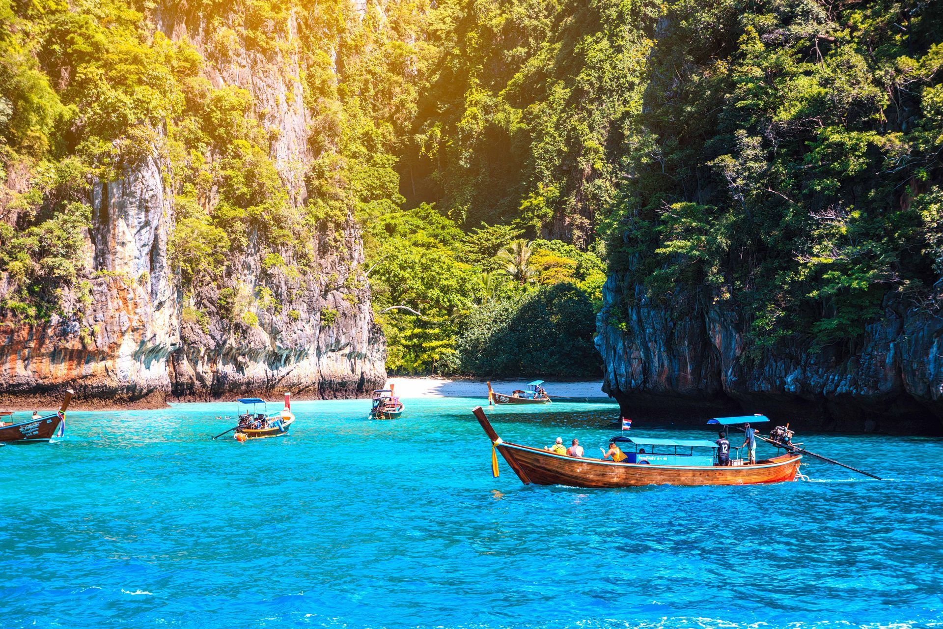 Boats drifting by the famous Maya Bay, a beach located in Koh Phi Phi Leh, Krabi Province, Thailand.