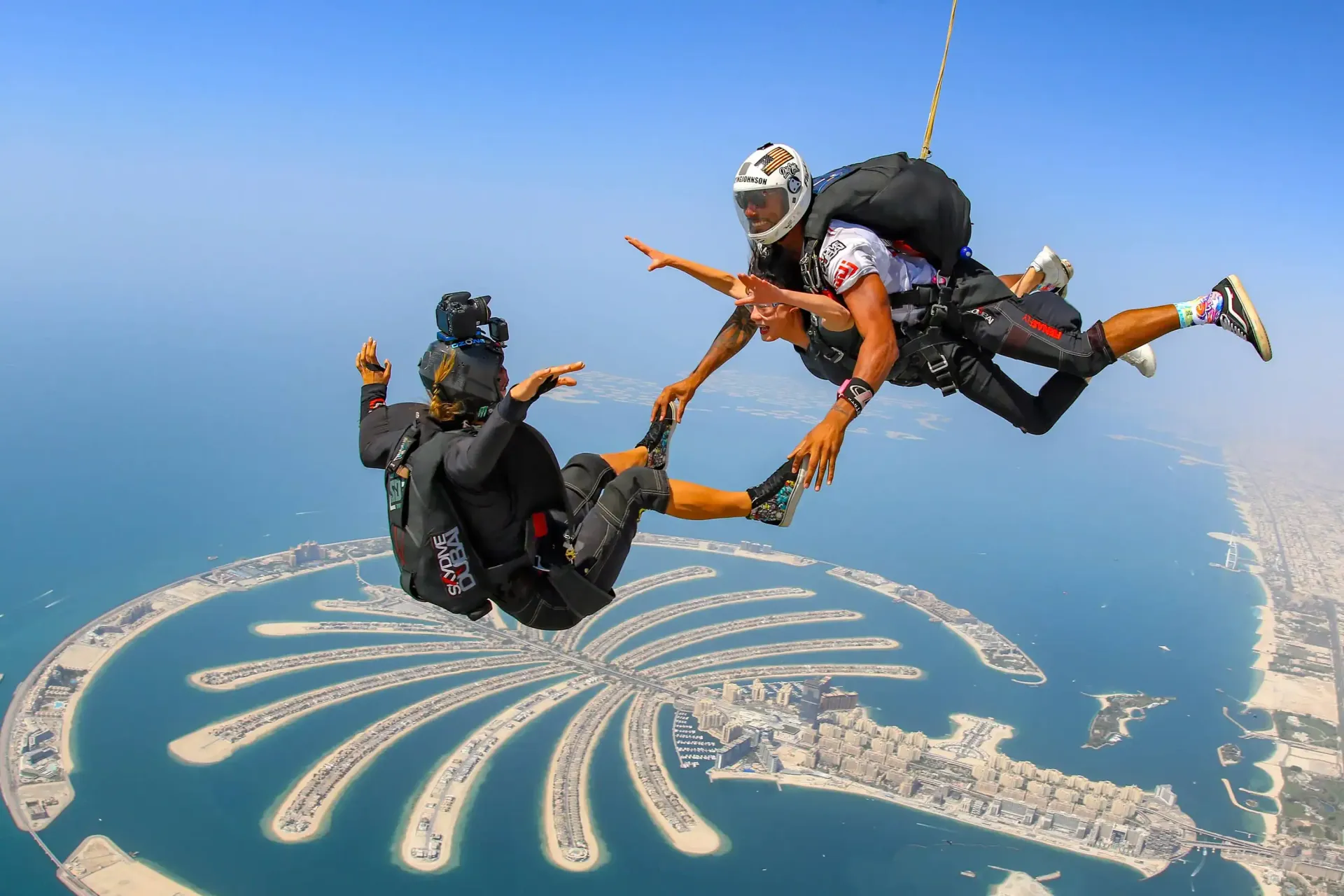 A group of people are flying through the air over a palm tree island.