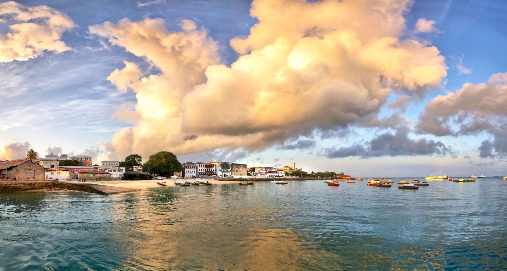 A large body of water with boats in it and a city in the background.