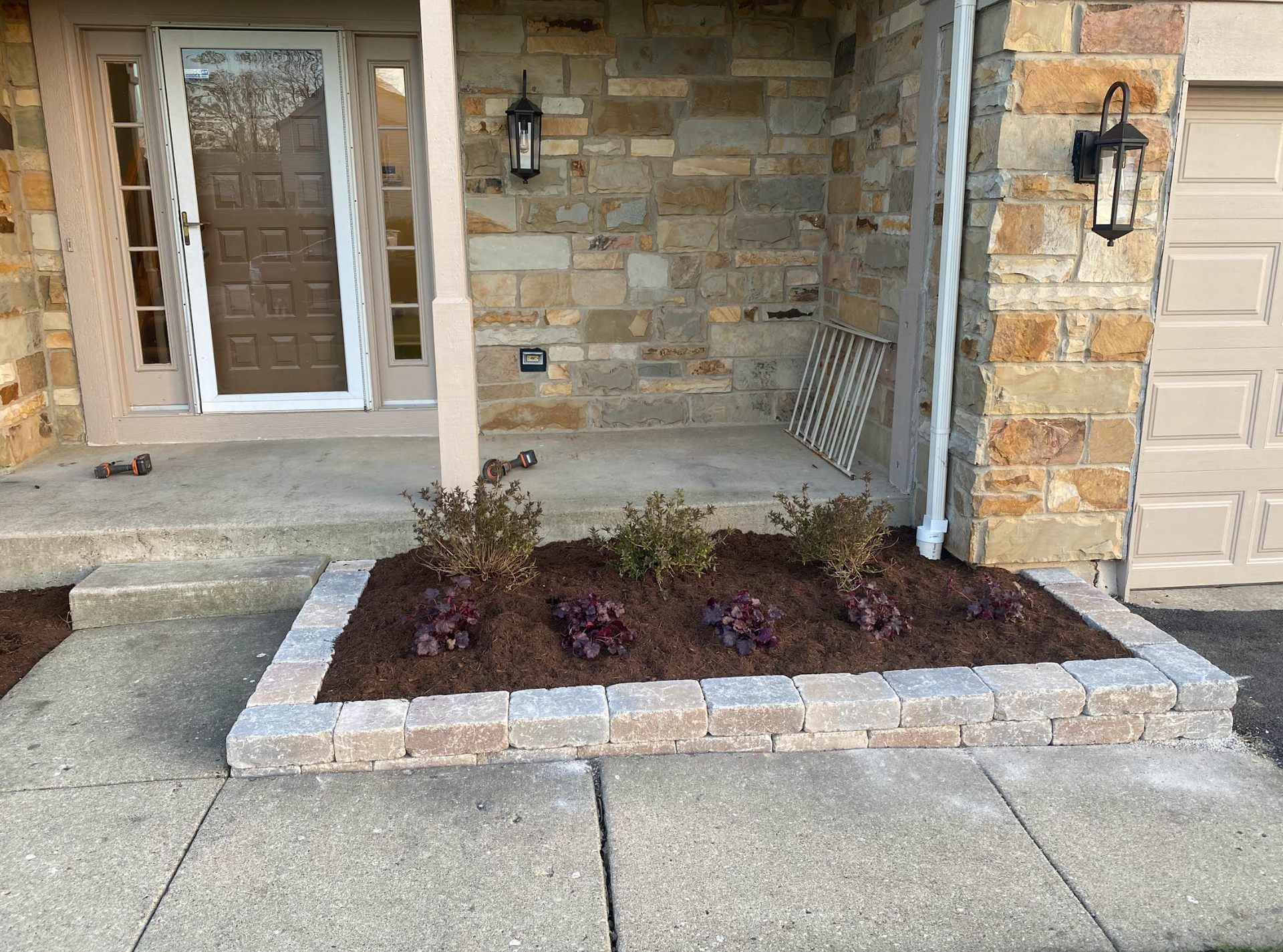 A stone house with a planter in front of it.