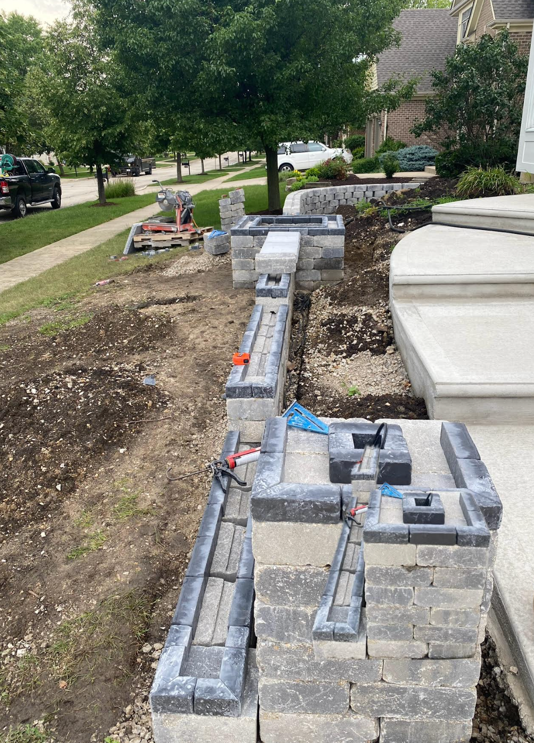 A brick wall is being built in front of a house.