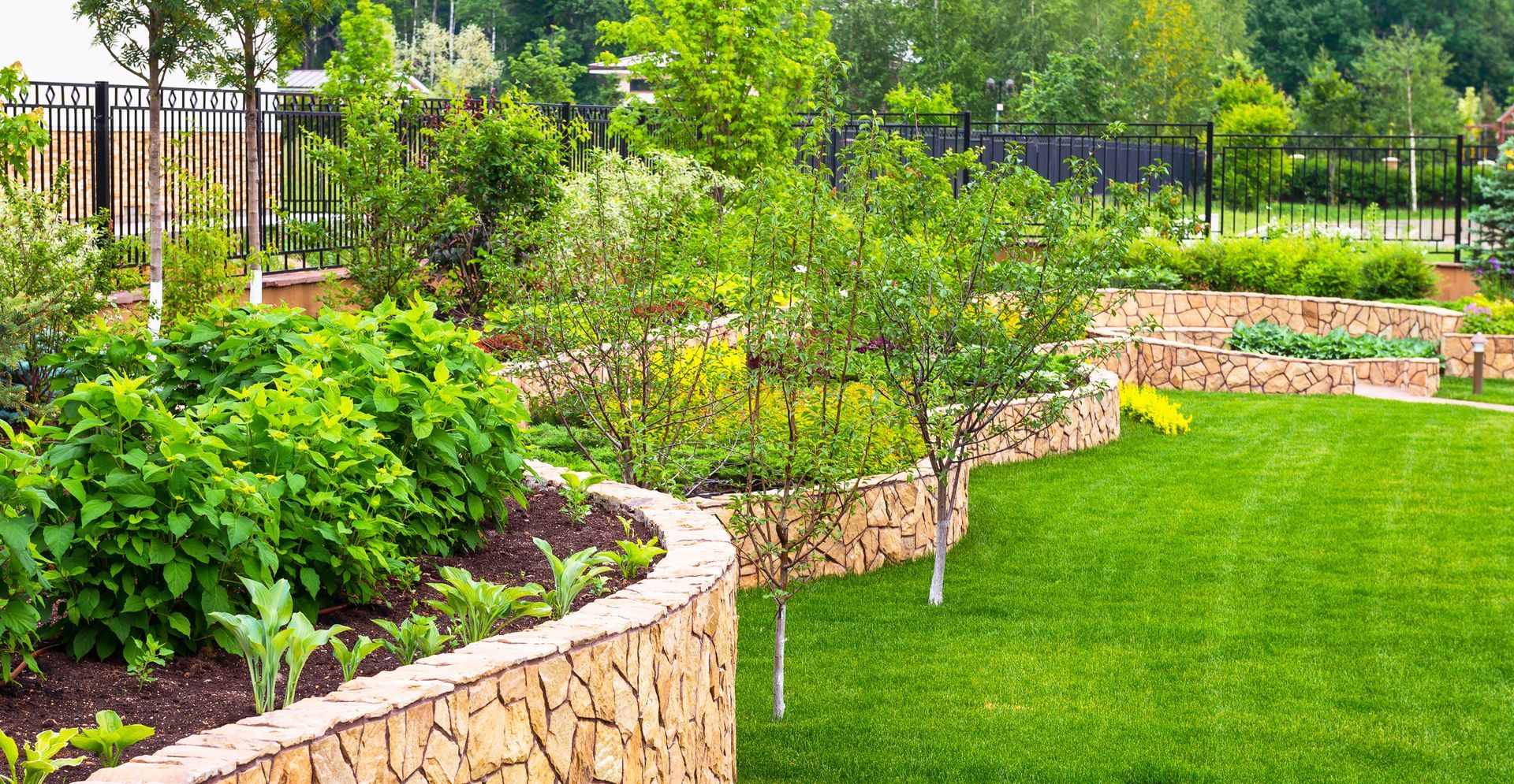 There is a stone wall in the middle of the garden.