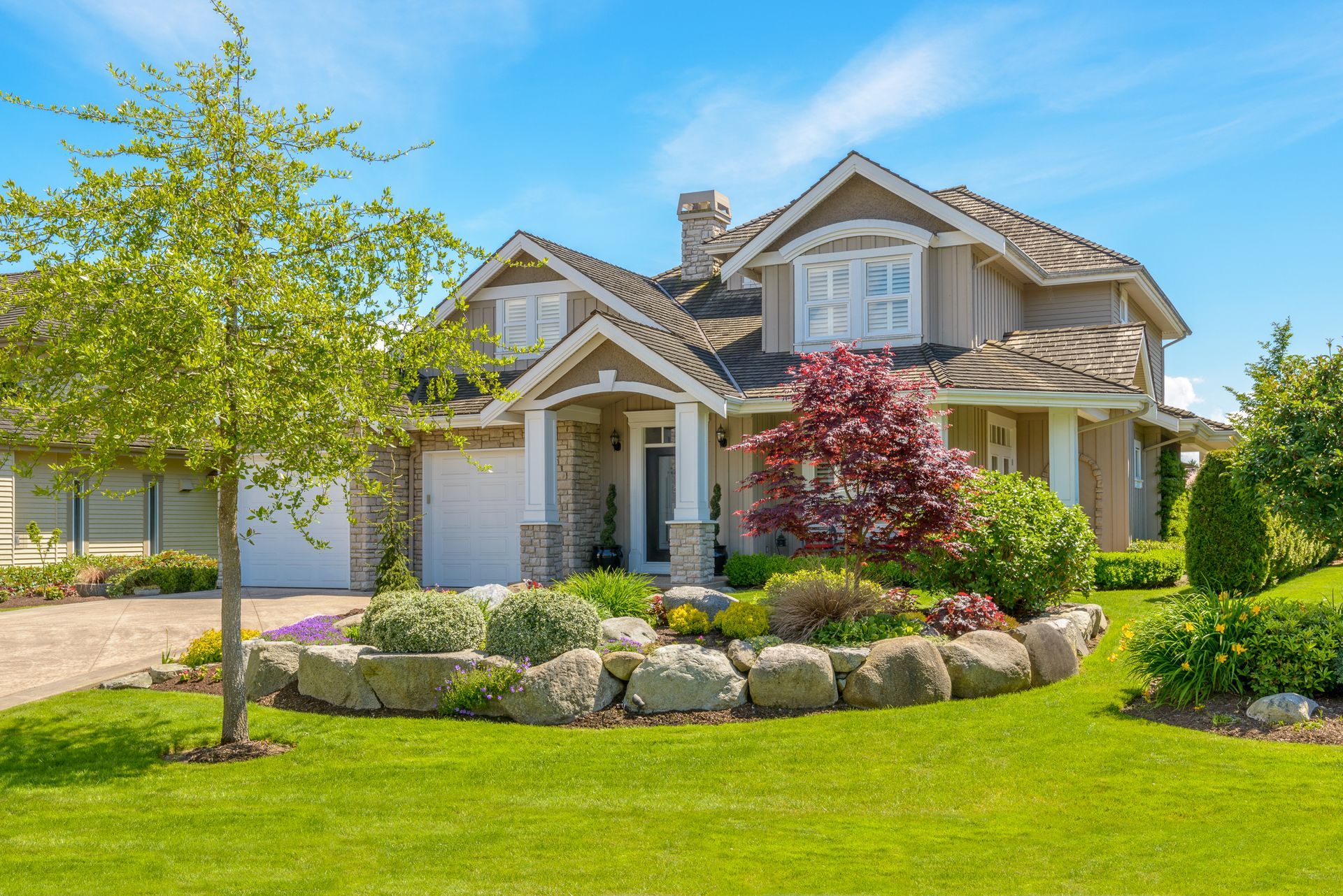 A large house with a lush green lawn in front of it.