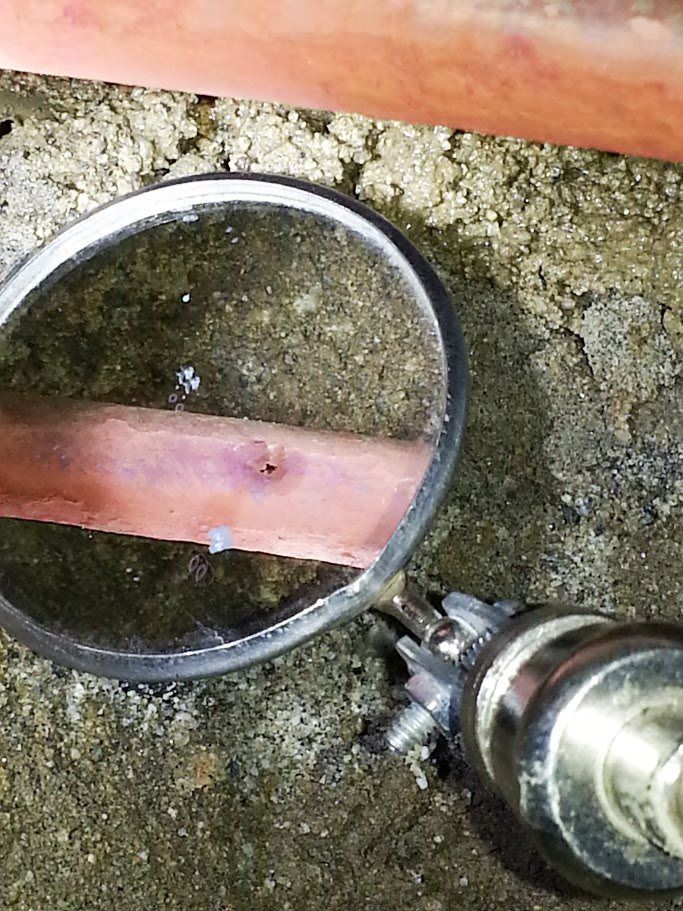 A magnifying glass is sitting on the ground next to a door knob.
