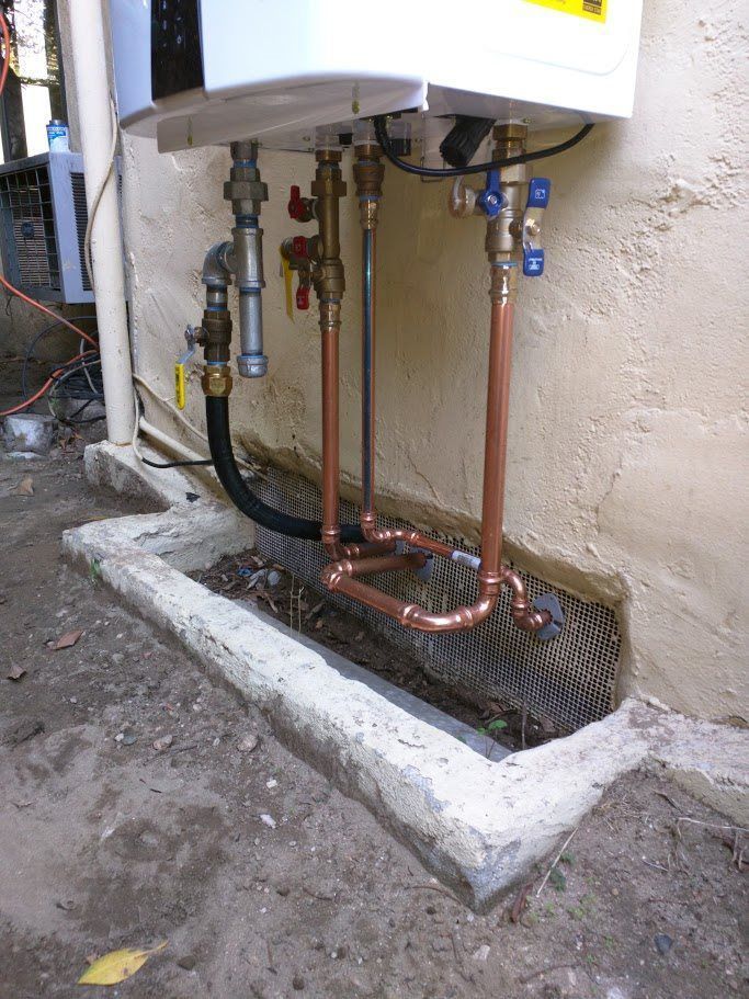 A white water heater with copper pipes attached to it