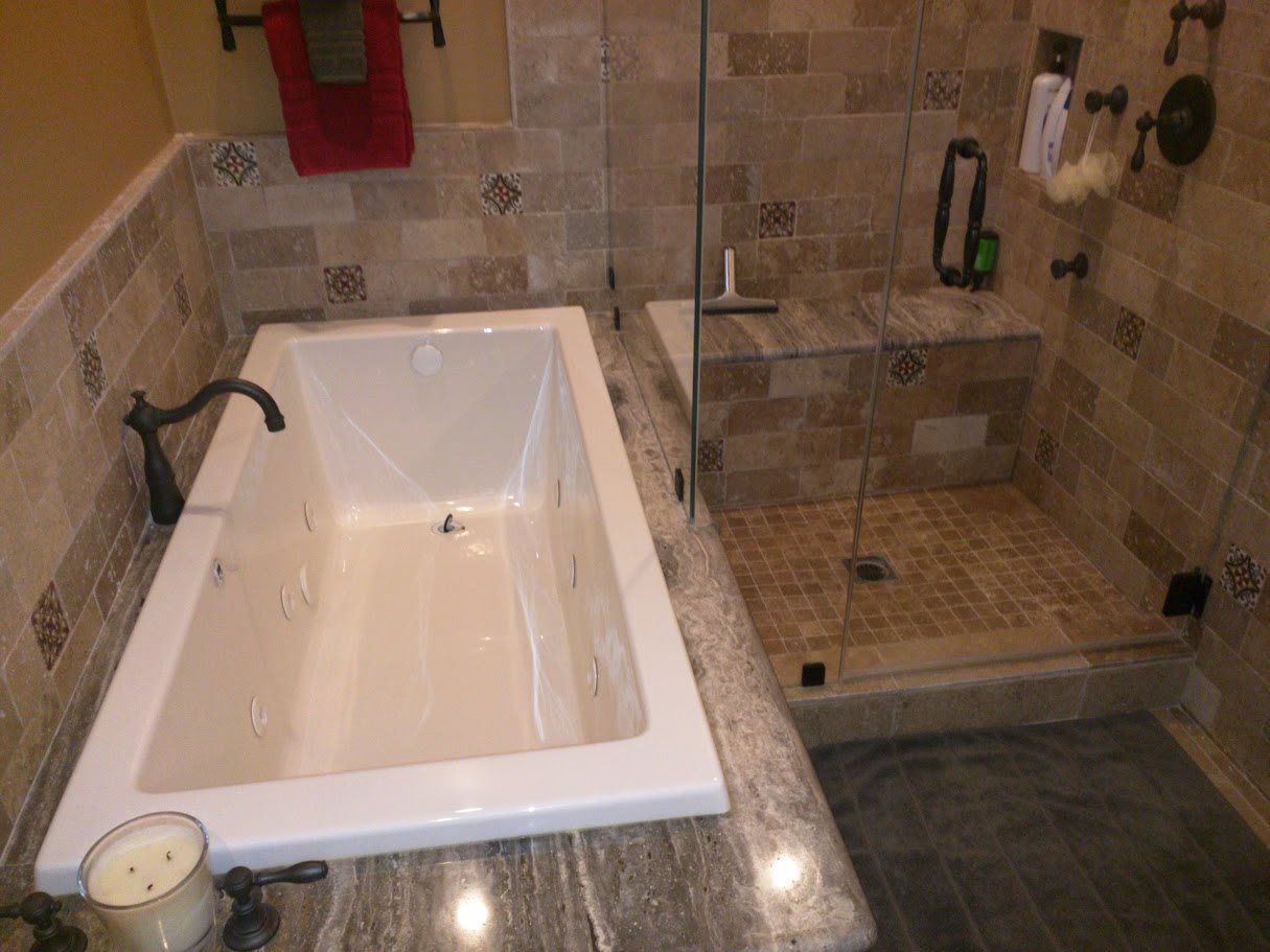 A bathroom with a jacuzzi tub and a walk in shower.