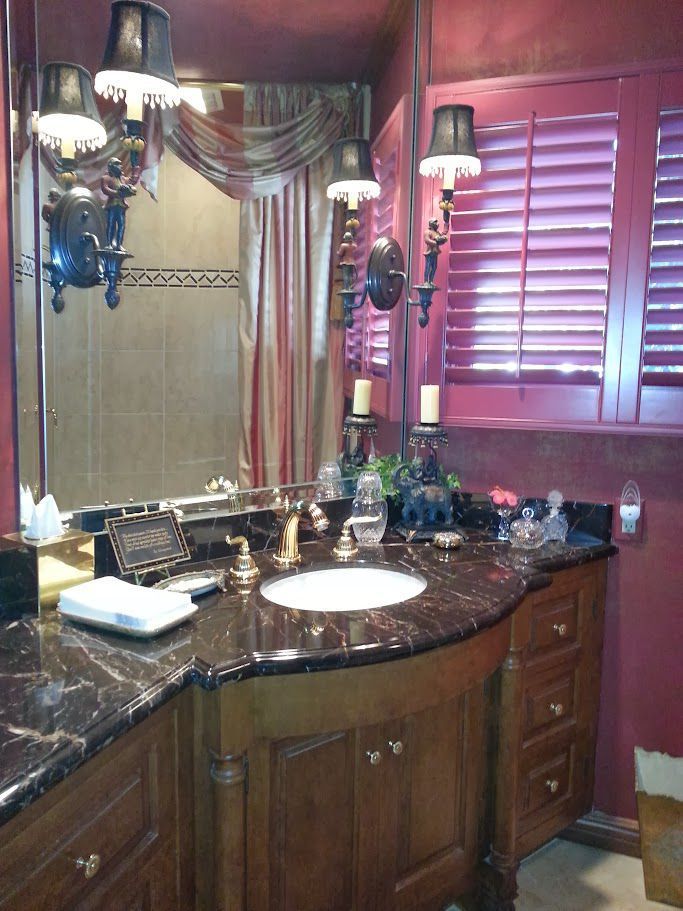 A bathroom with a sink a mirror and shutters