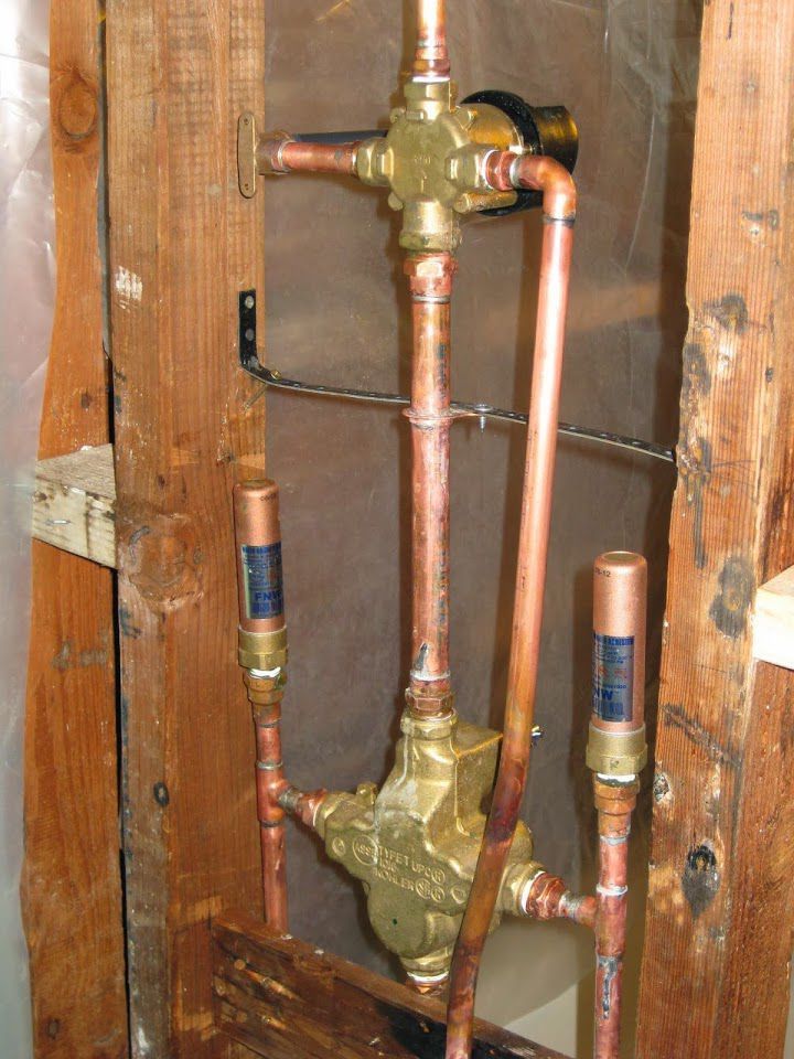 Copper pipes are connected to a brass valve which says ' copper ' on it