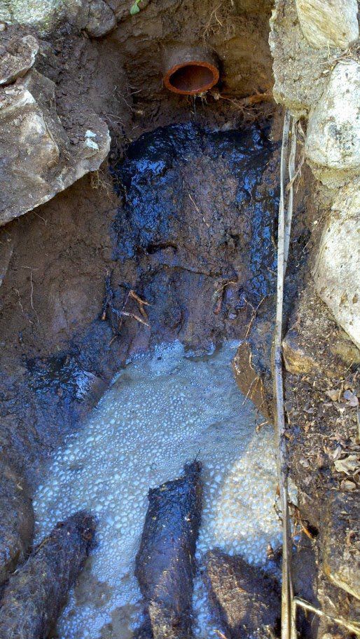 A close up of a hole in the ground with water coming out of it.