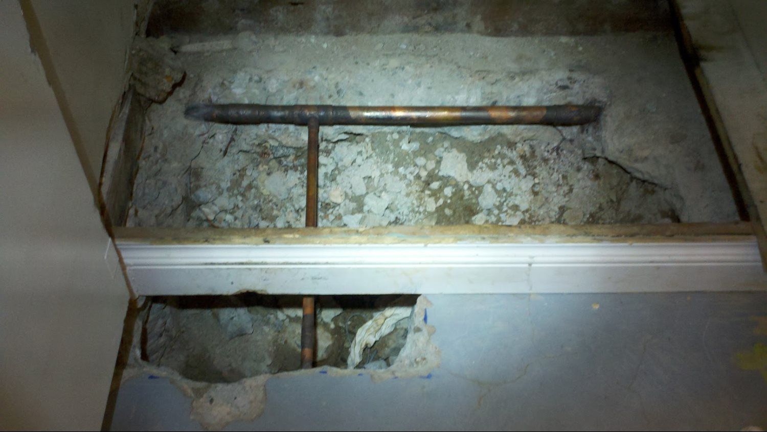 A hole in the floor with a pipe coming out of it.