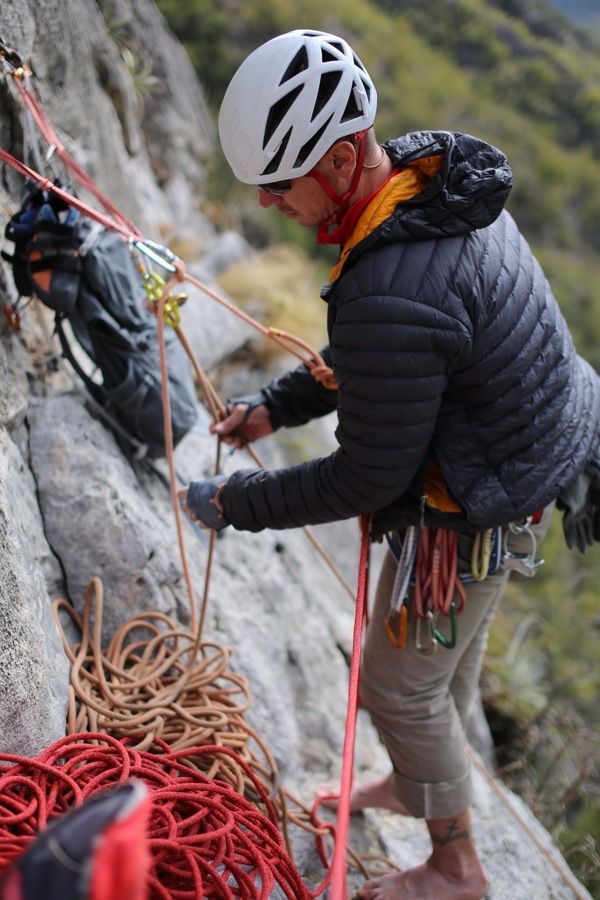 A man wearing a helmet is climbing a rock wall.