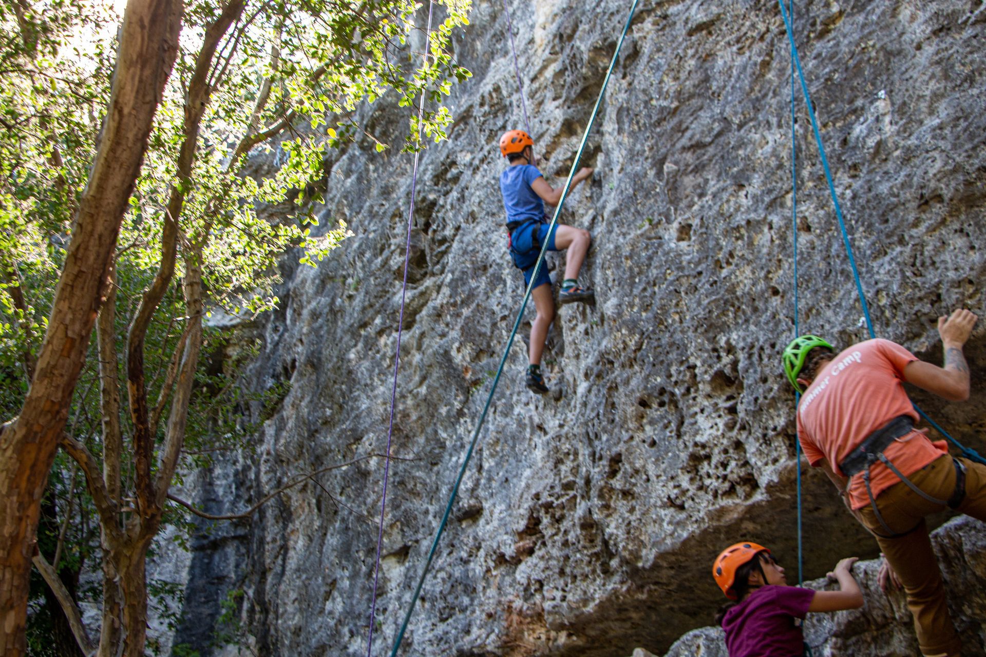 A group of people are climbing up a rock wall.