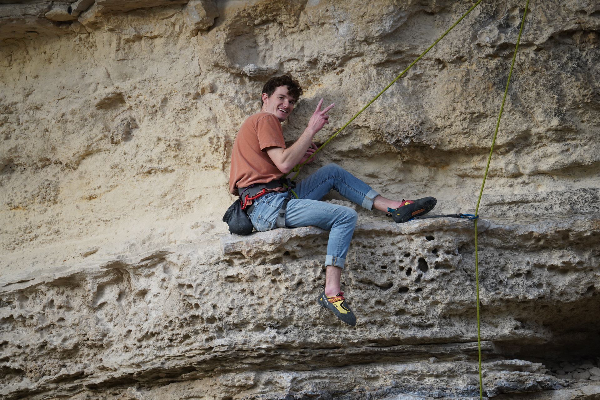 A man is sitting on top of a rock wall