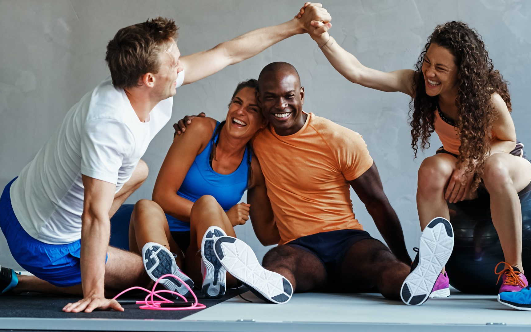 een groep mensen geeft elkaar een high five in een sportschool.