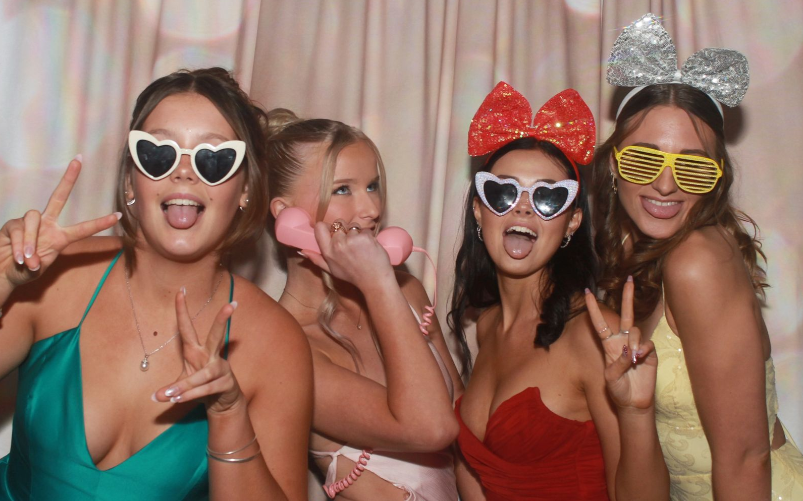 Photo booth at an event with a red carpet and guests in the background. The booth has a glowing outline and screen.