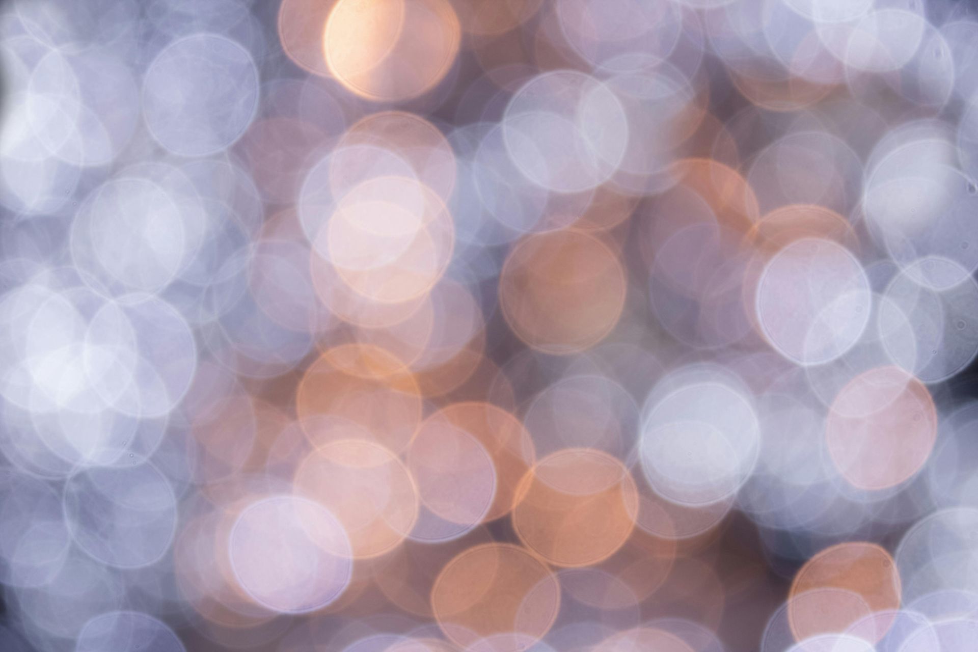 Blurred lights, silver and orange, create a festive bokeh effect.