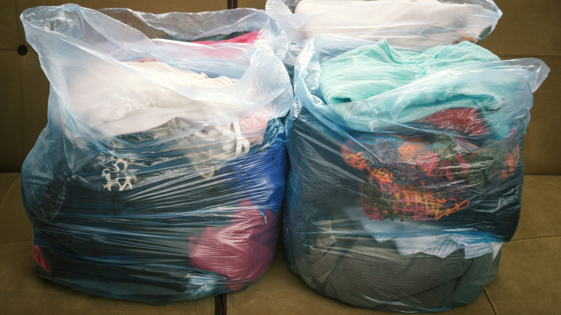 Neatly packed plastic bags of laundered clothes and stripped bedding ready for a pest control treatment.
