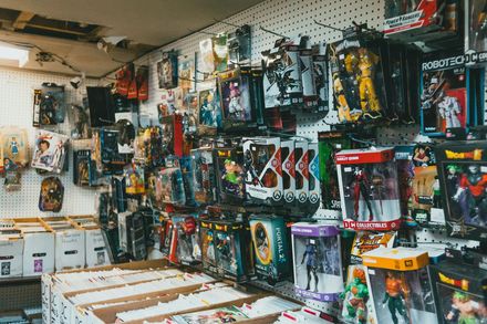 A wall display in a hobby shop featuring rows of assorted action figures in their packaging.
