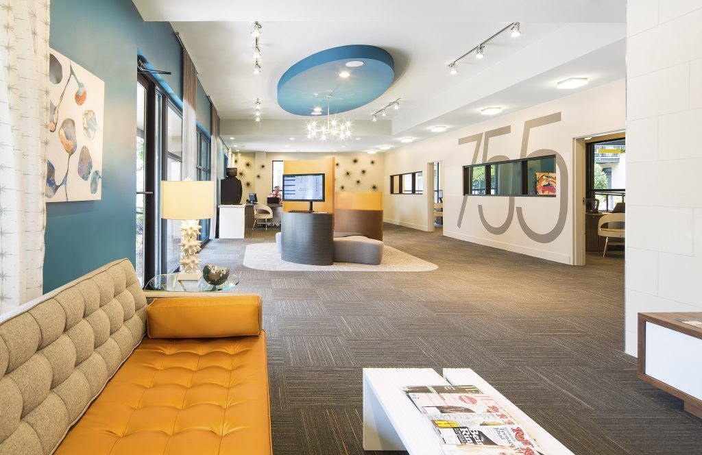 A clubhouse with a yellow couch and a white coffee table.