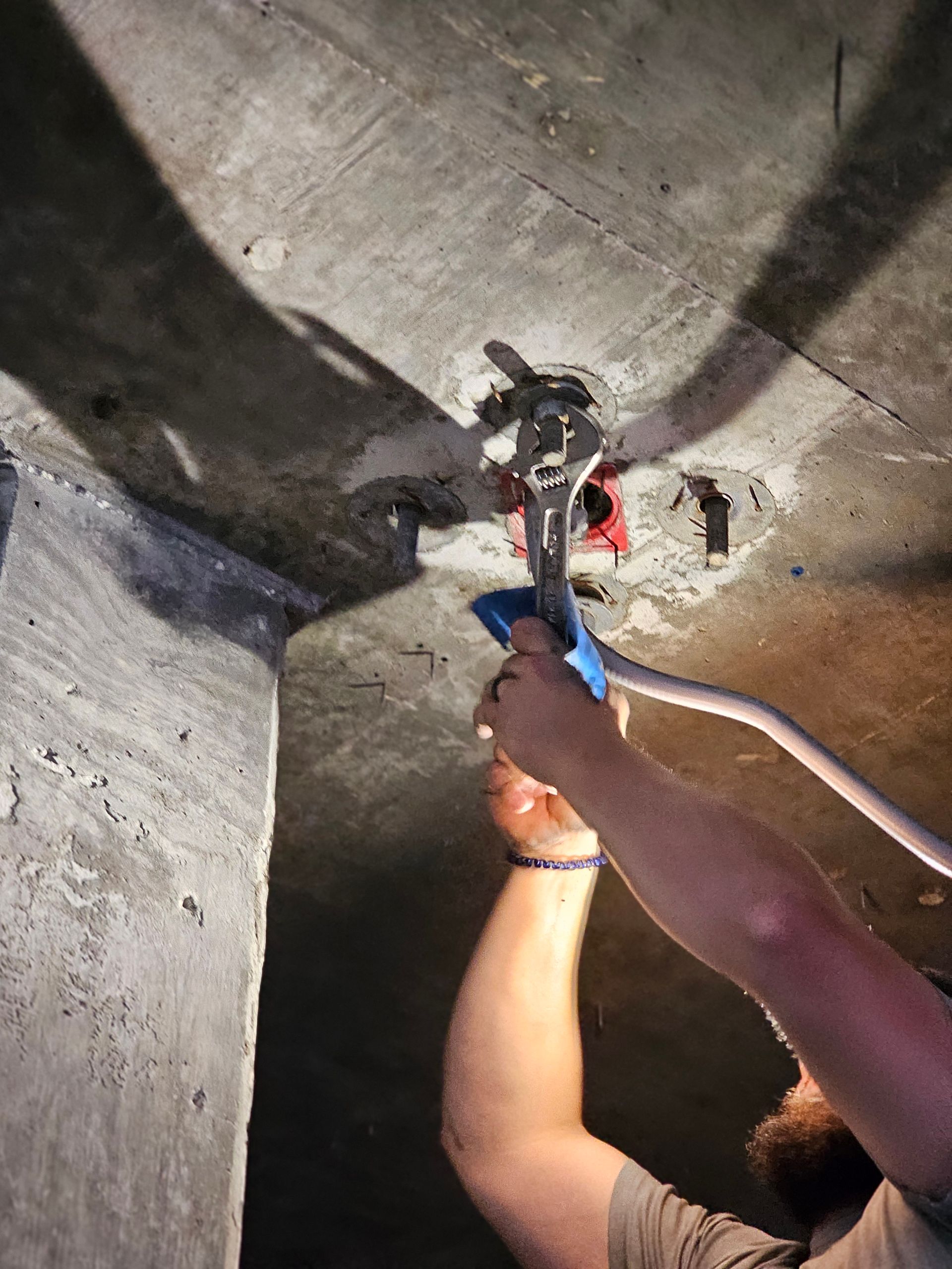 A man is working on a concrete wall with a wrench - Milton, FL - Damn Fine Jobs
