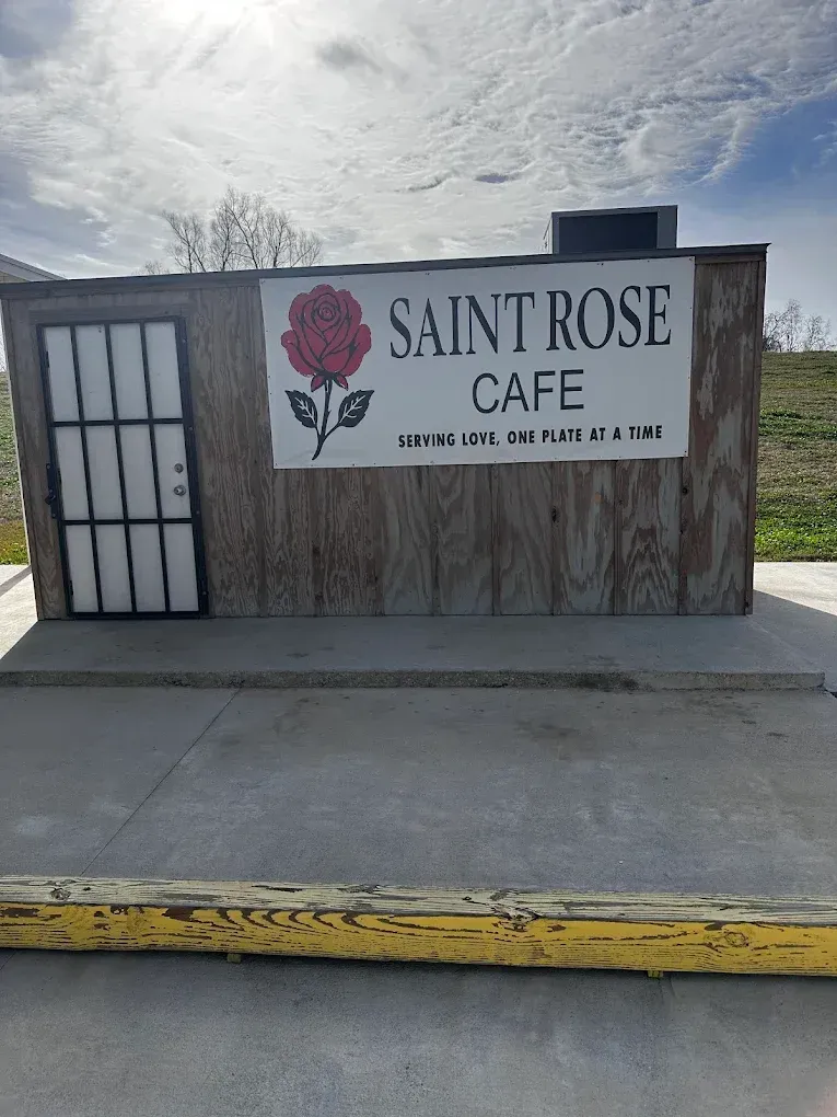 Saint Rose Cafe sign on a roadside building under a cloudy sky