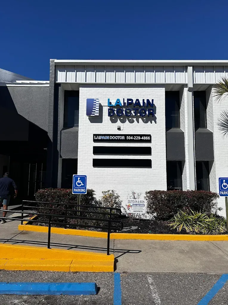 Black-and-white building facade with the main entrance sign for Palm Beach County Schools under a blue sky