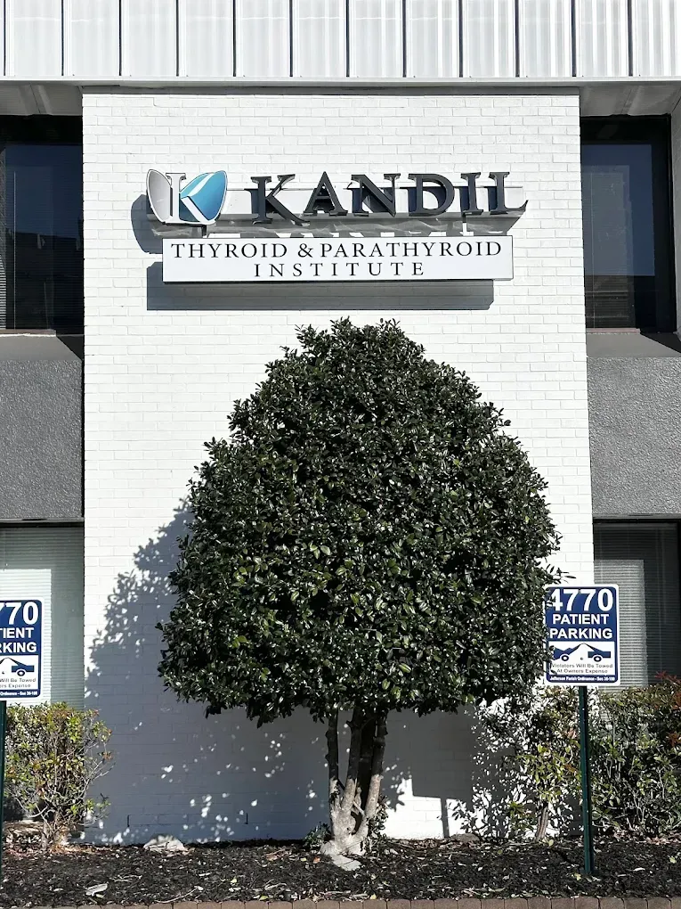 Kandil Thyroid Institute sign on white building with a trimmed tree in front