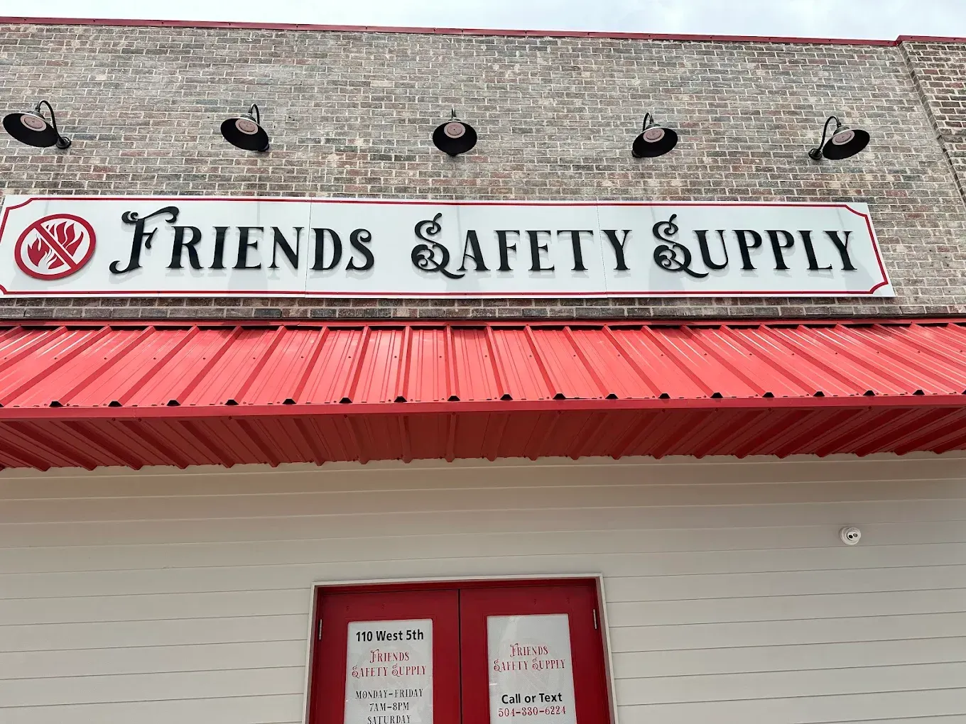 Storefront sign reading “Friends & Safety & Supply” above a red awning.