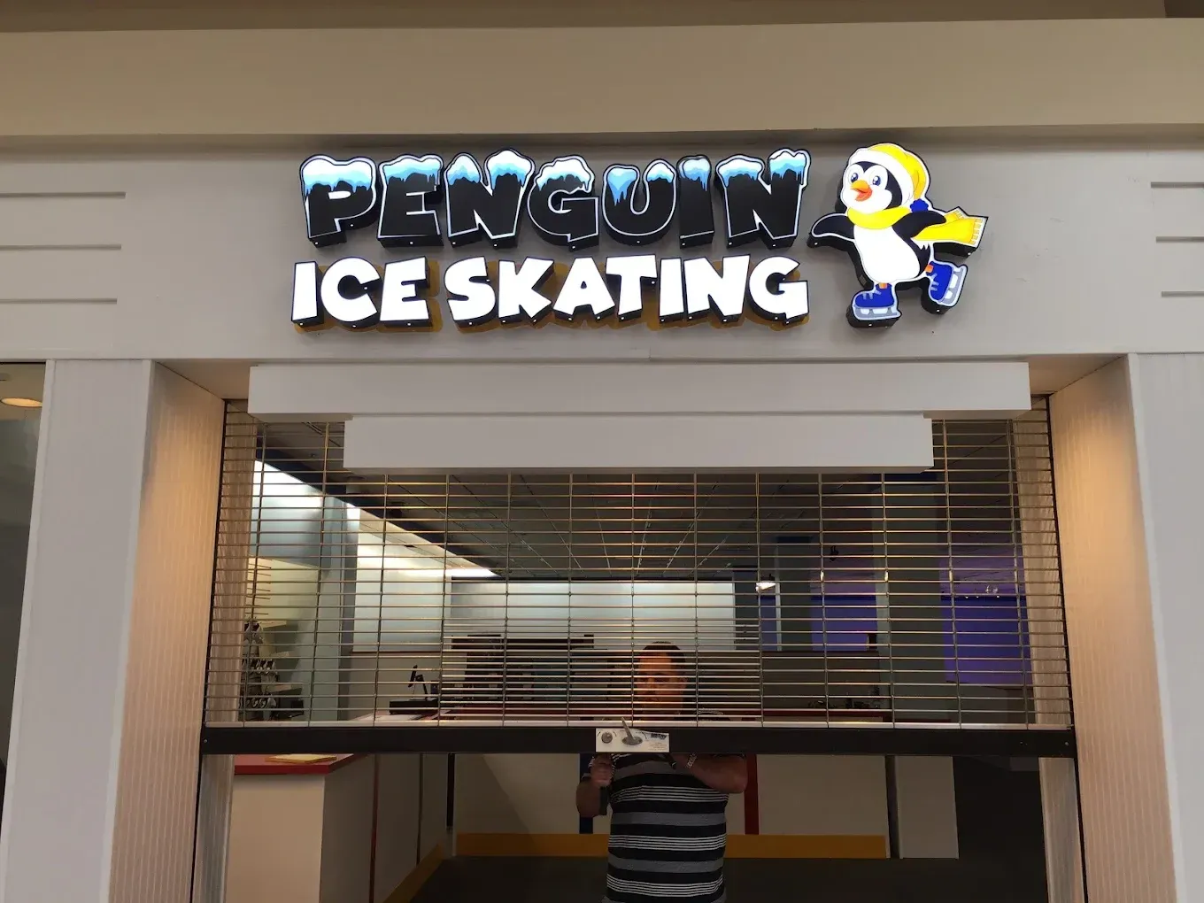 Penguin Ice Skating sign above a mall storefront with a penguin mascot logo