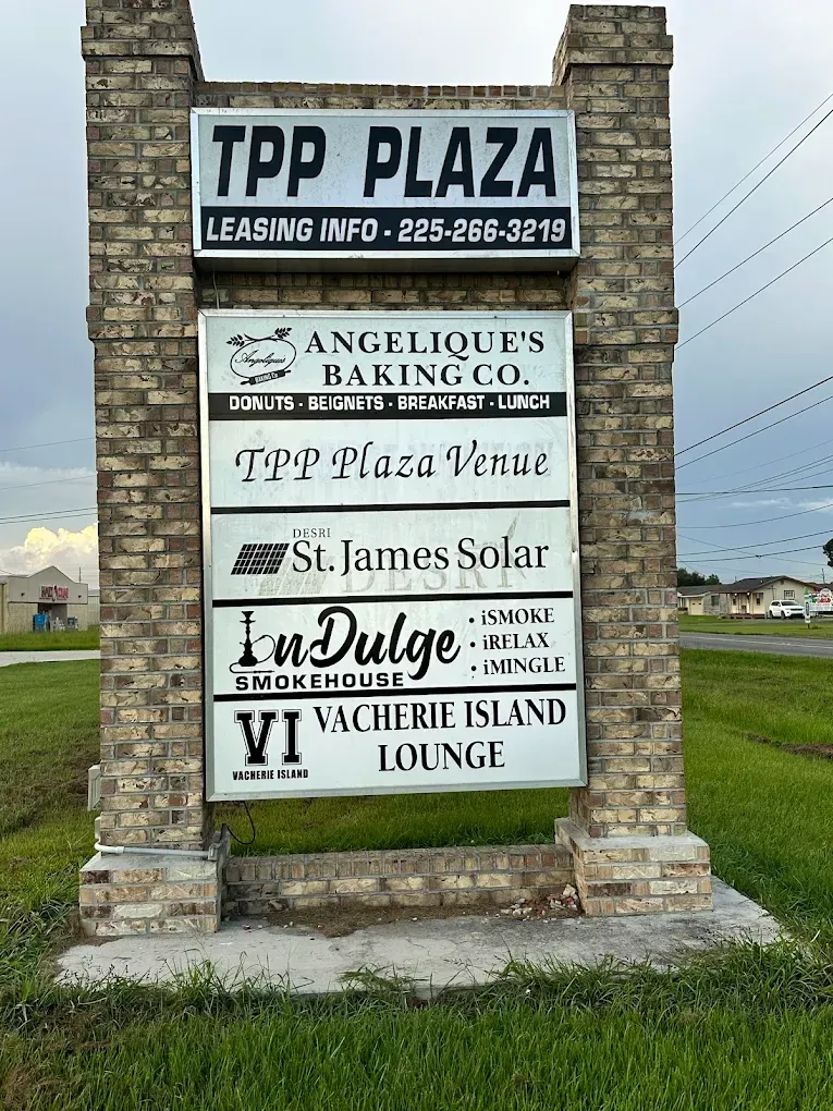 TPP Plaza sign listing bakery, venue, salon, bistro, and lodge businesses by a roadside