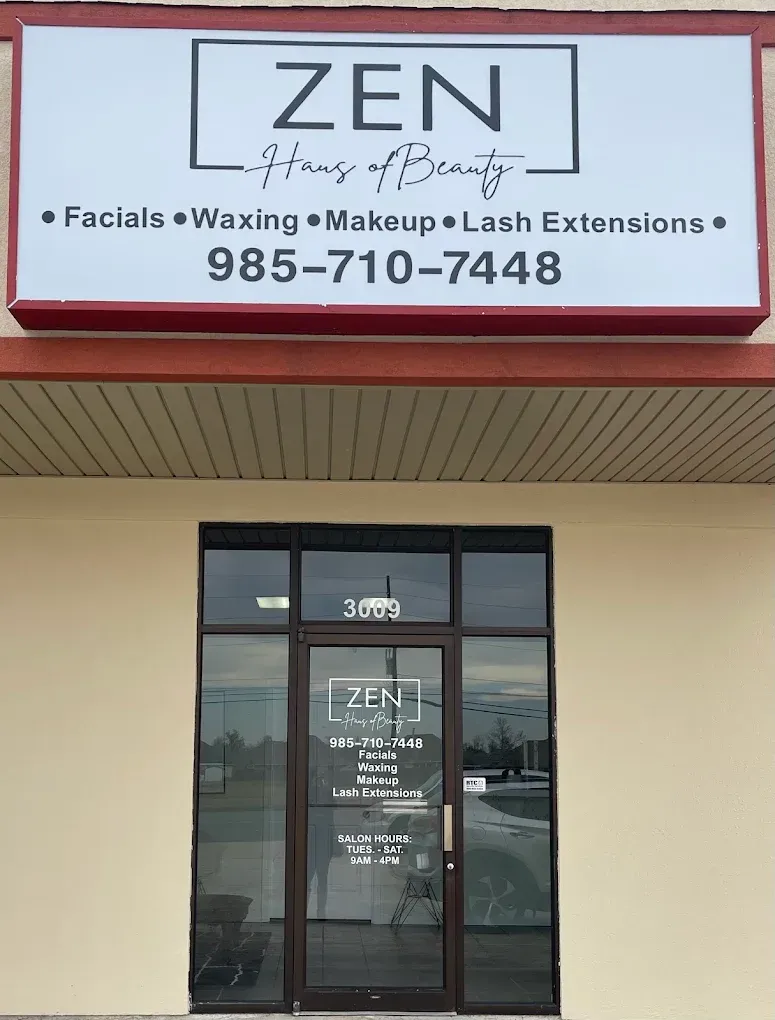 Storefront sign for ZEN at Joyce Beauty, offering facials, waxing, makeup, and lash extensions, with phone number.
