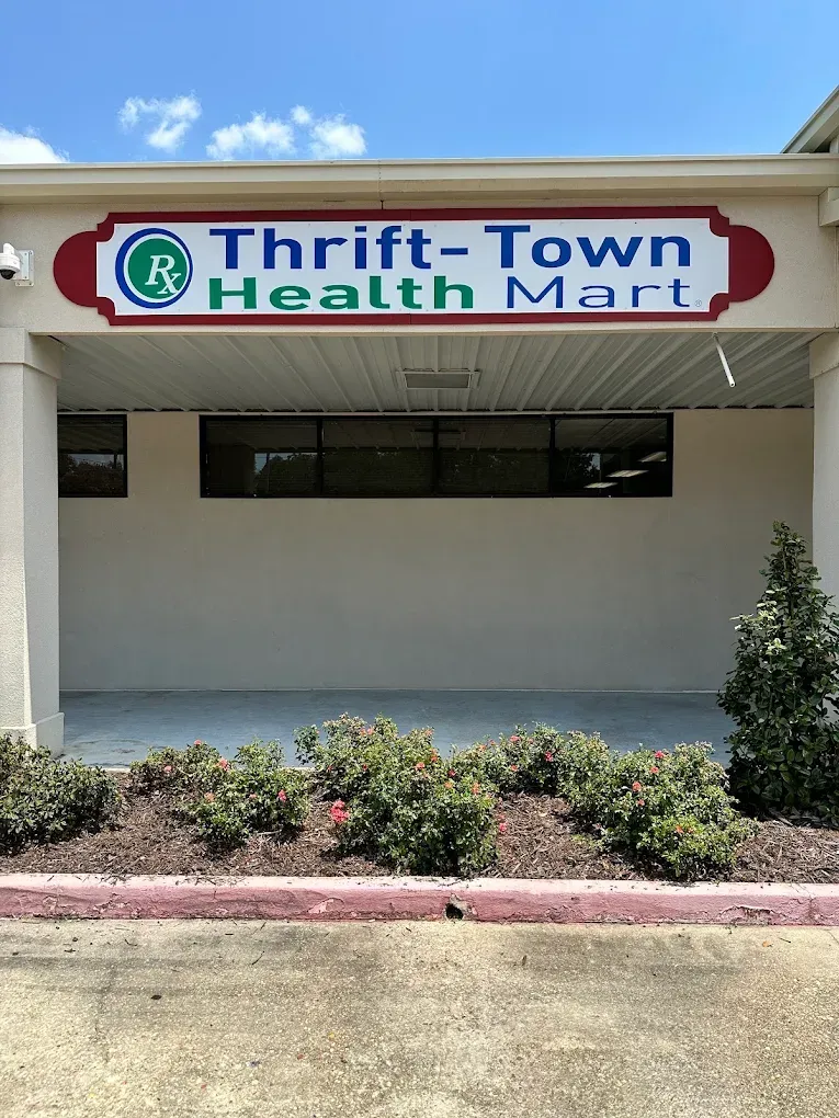 Thrift-Town Health Mart storefront sign above a beige building with shrubs in front