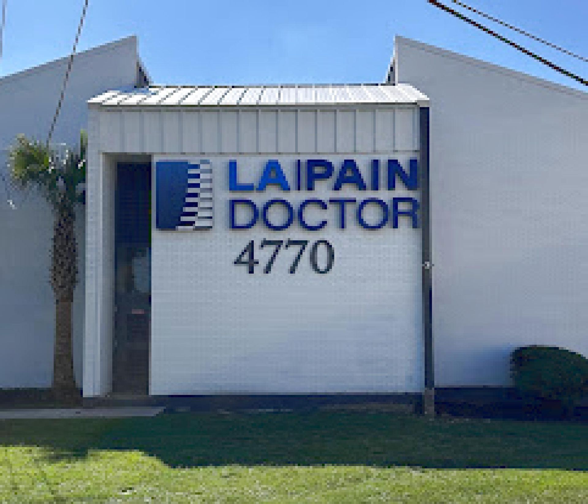 Laipain Doctor clinic sign on a white building, number 4770, with grass in front.
