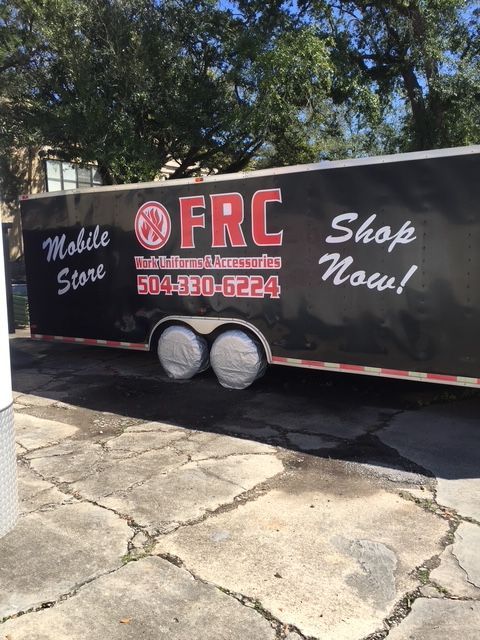 Black mobile stone trailer with “FRC” and “Shop Now!” parked on a driveway under trees