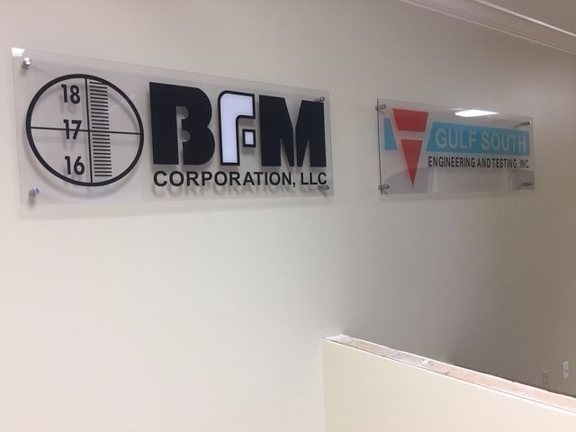 Wall with BGM Corporation, LLC and ClearSource Insurance Services signs beside a clock logo