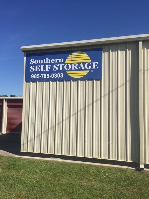 Southern Self Storage sign on tan building with blue sky and grass in front