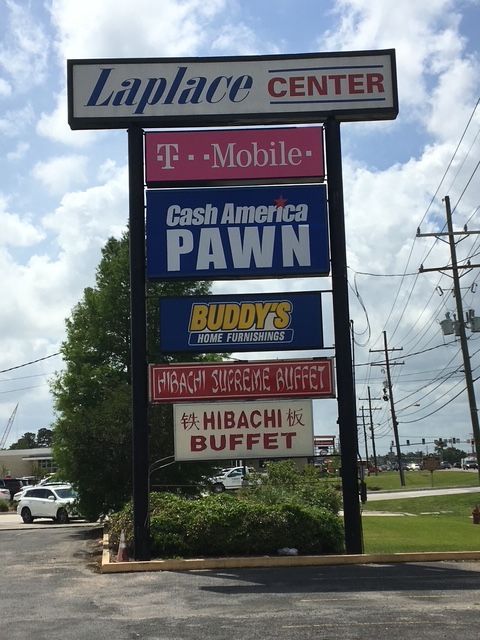 Roadside sign for Laplace Center with T-Mobile, Cash America Pawn, Buddys, and hibachi buffet listings
