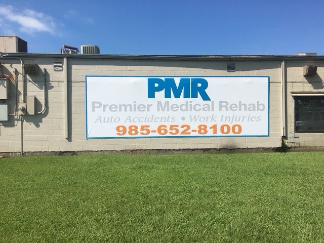 Premier Medical Rehab sign on beige building with blue and orange text
