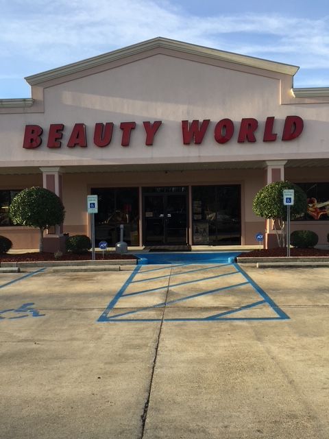 Beauty World storefront with glass entrance, red sign, and accessible parking spaces in front
