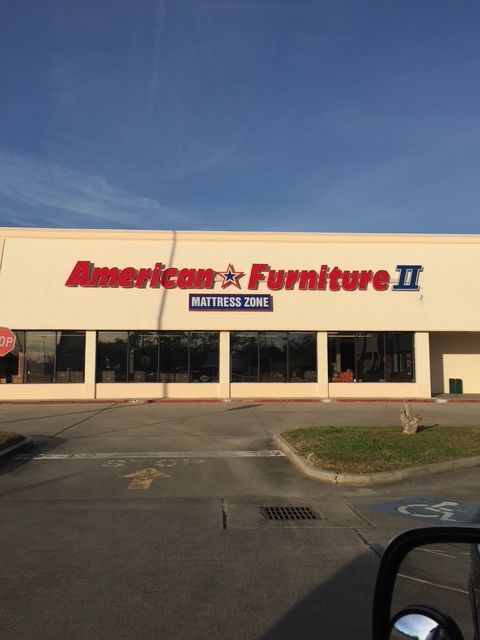 American Furniture II storefront with beige facade and red signage under a blue sky
