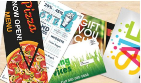 Assorted colorful flyers and brochures fanned out on a light wooden surface
