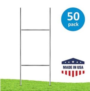 Two metal stakes on grass with a blue
