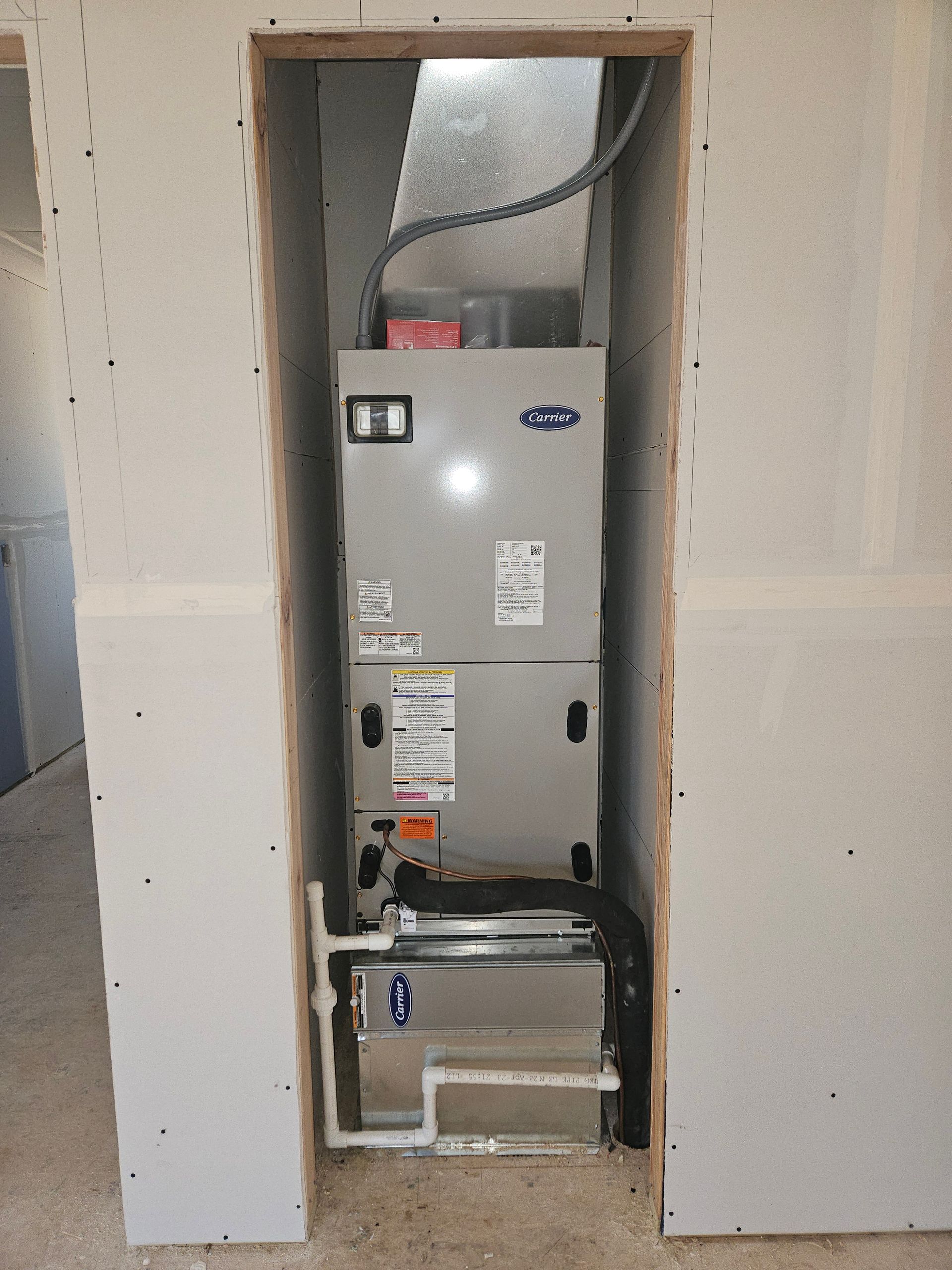 HVAC unit installed in a wall cavity, with ductwork and framing visible.