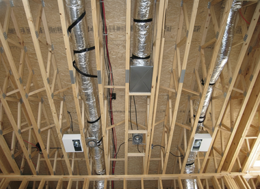 Wooden attic framing with HVAC ductwork and equipment installed.