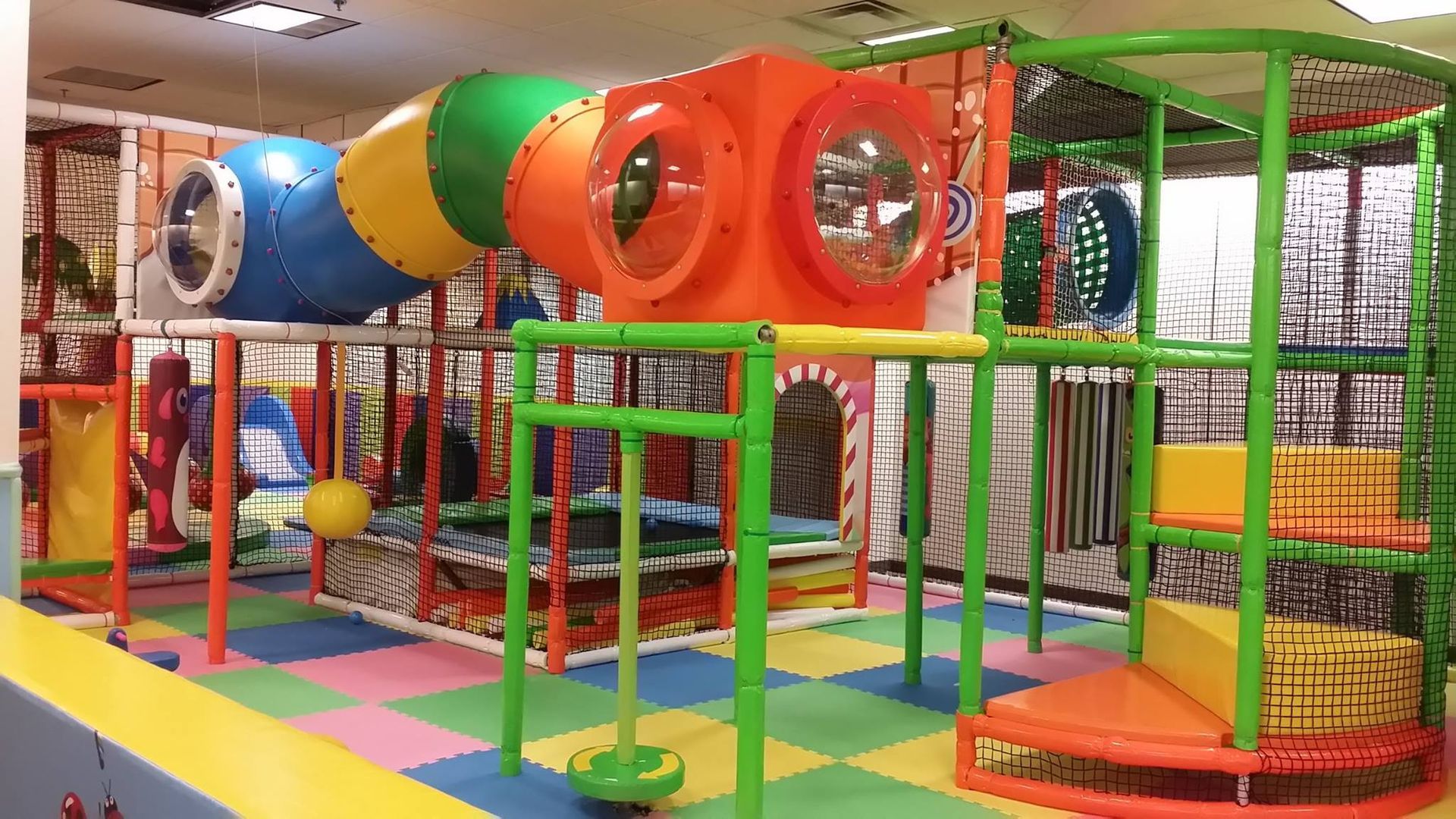 A colorful playground with a slide , stairs , and tunnels.