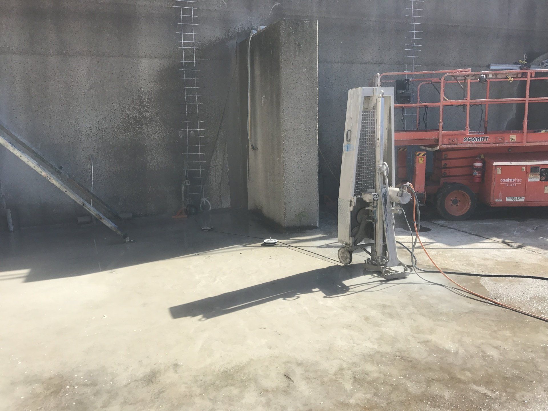 A concrete wall is being cut with a machine.