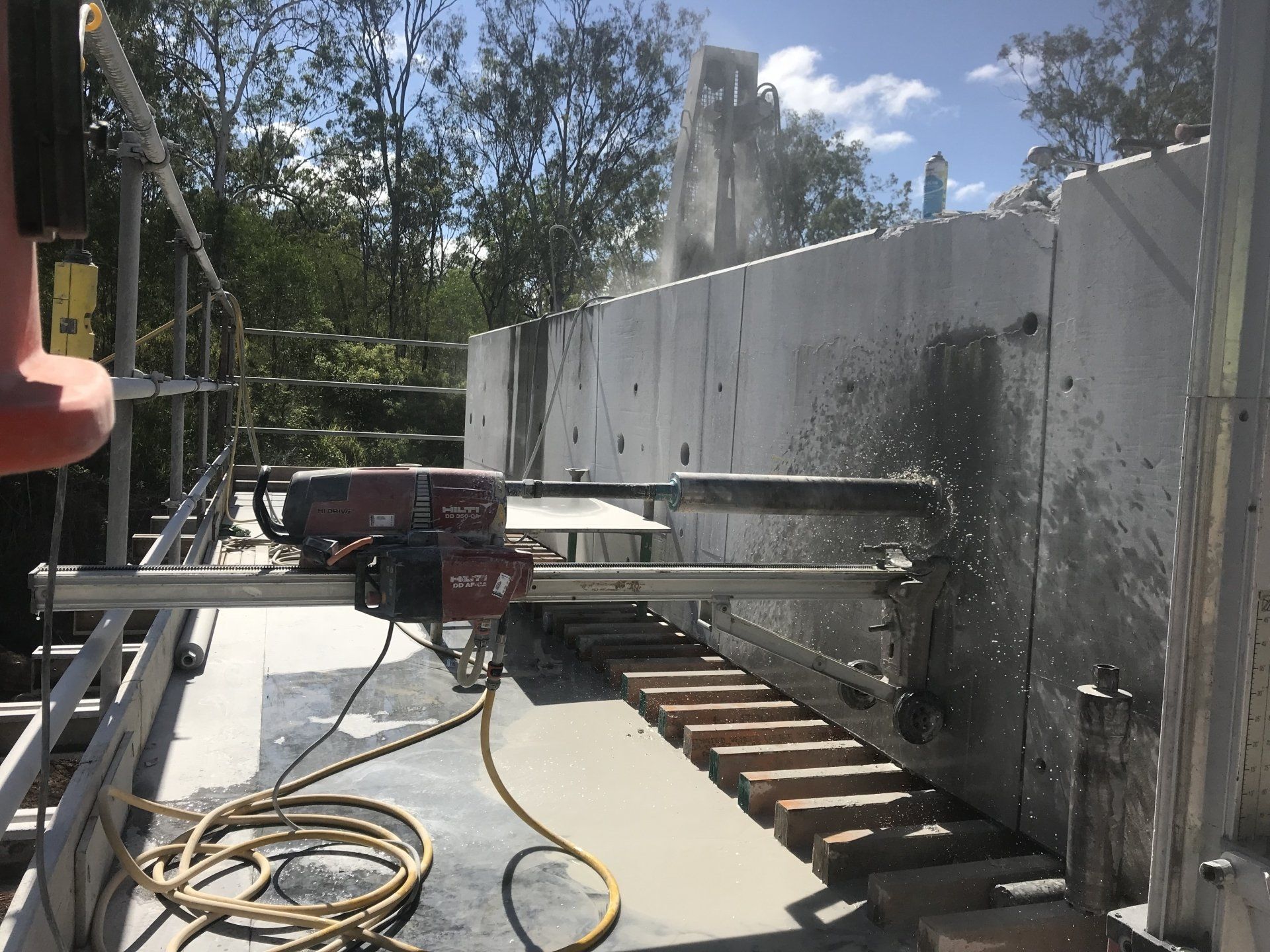 A person is cutting a concrete wall with a machine.
